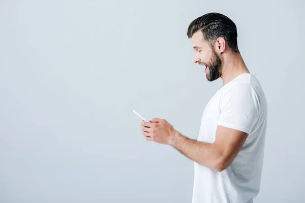 Side view of excited man using smartphone isolated on grey — Stock Photo