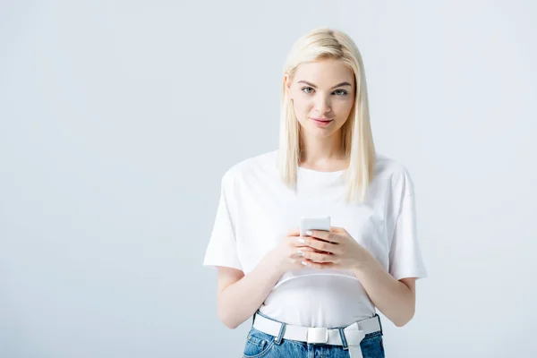 Beautiful blonde girl using smartphone isolated on grey with copy space — Stock Photo