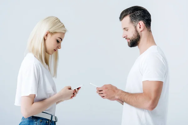 Man and beautiful girl using smartphones on grey — Stock Photo