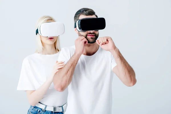 Man with clenched fists and girl in Virtual reality headsets isolated on grey — Stock Photo