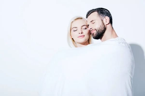 Girlfriend and boyfriend covered in blanket with closed eyes on white — Stock Photo