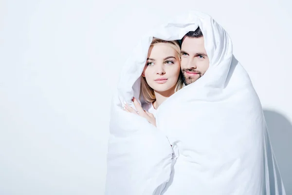 Hermosa novia y guapo novio cubierto en manta en blanco - foto de stock