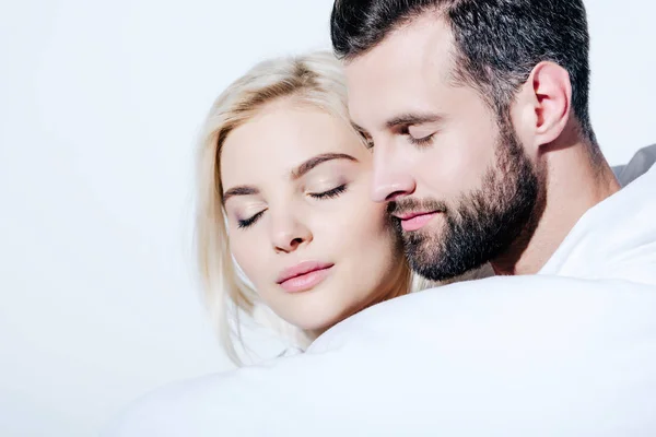 Namorada e namorado coberto de cobertor com os olhos fechados isolado no branco — Fotografia de Stock