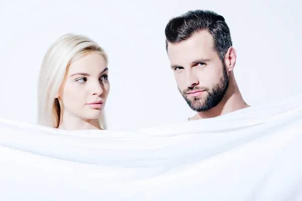Namorada e bonito namorado segurando cobertor isolado no branco — Fotografia de Stock
