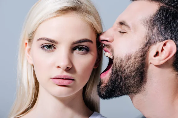 Homme criant sur belle jeune femme regardant caméra isolé sur gris — Photo de stock