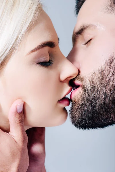 Крупный план красивой чувственной пары, целующейся в одиночестве на сером — стоковое фото