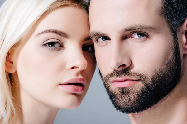 Hombre guapo y hermosa mujer joven mirando la cámara aislada en gris - foto de stock