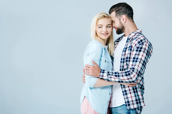 Mann umarmt schöne lächelnde junge Frau isoliert auf grau mit Kopierraum — Stockfoto