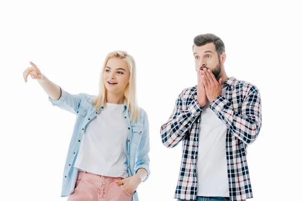 Chica señalando con dedo cerca sorprendido hombre cubriendo boca aislado en blanco - foto de stock