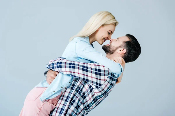 Schönes junges Paar umarmt isoliert auf grau — Stockfoto