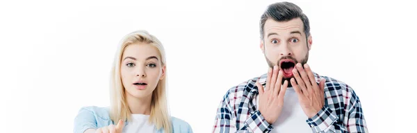 Plano panorámico de chica señalando con el dedo y hombre sorprendido cubriendo la boca aislado en blanco - foto de stock