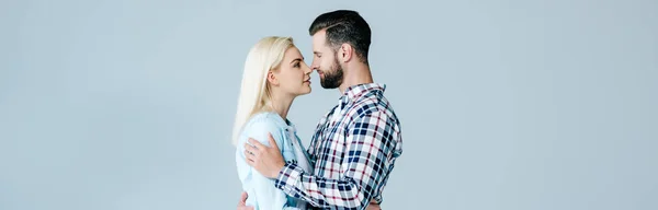 Panoramaaufnahme eines schönen jungen Paares, das sich isoliert auf grau umarmt — Stockfoto