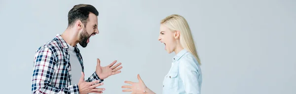 Tiro panorâmico de homem e mulher gritando e gesticulando isolado em cinza — Fotografia de Stock