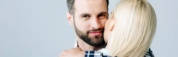 Plan panoramique de l'homme regardant la caméra et embrassant fille isolée sur gris — Photo de stock