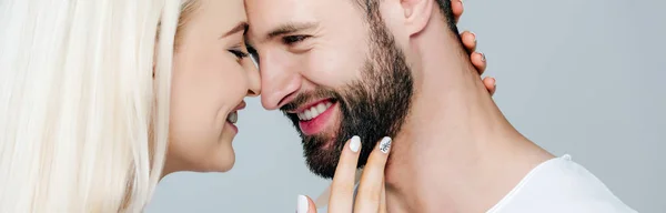 Панорамный снимок красивой девушки, обнимающей мужчину и улыбающейся изолированной на сером — стоковое фото