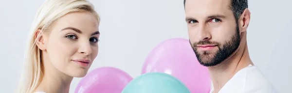 Panoramic shot of man and beautiful girl with balloons isolated on grey — Stock Photo