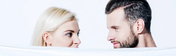 Panoramic shot of girlfriend and handsome boyfriend holding blanket isolated on white — Stock Photo