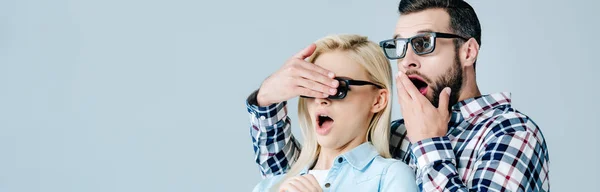 Panoramaaufnahme eines schockierten Mannes, der die Augen eines Mädchens mit 3D-Brille verdeckt, während er einen Film isoliert auf grau anschaut — Stockfoto