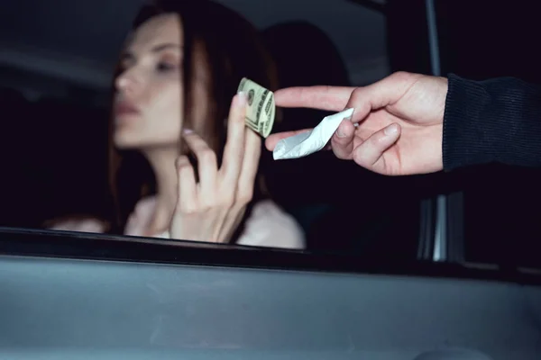 Mujer en coche con billetes de dólar comprando drogas de matón - foto de stock