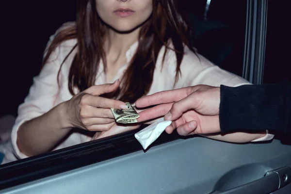 Cropped view of woman in car with dollar banknotes buying drugs from thug — Stock Photo