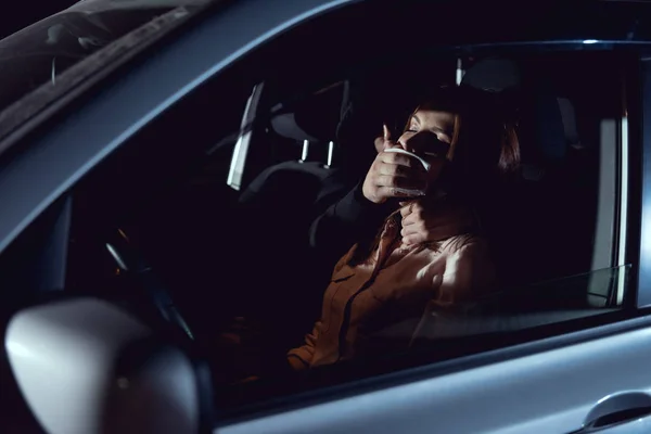 Thief attacking beautiful frightened woman in automobile at night — Stock Photo