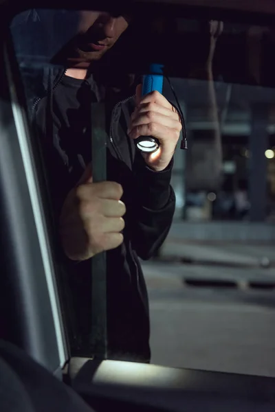 Vue recadrée du voleur voiture intrusive avec lampe de poche et pied-de-biche — Photo de stock