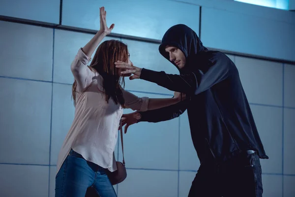 Woman defending herself from attacking thief in underpass — Stock Photo