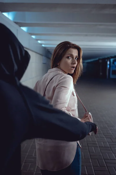 Ladrón robar bolsa de atractiva mujer en underpass — Stock Photo