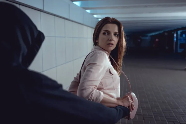 Thief stealing bag from beautiful woman in underpass — Stock Photo