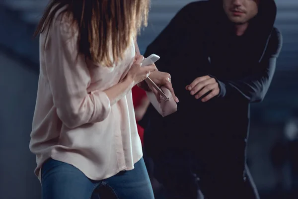 Partial view of thief stealing bag from woman in underpass — Stock Photo