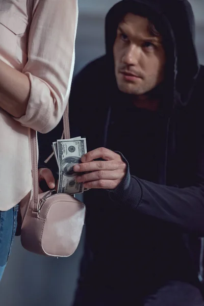 Voleur voler des billets en dollars dans un sac de femme — Photo de stock