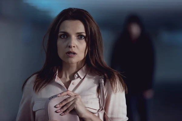 Selective focus of Terrified woman near thief holding bag and looking at camera — Stock Photo