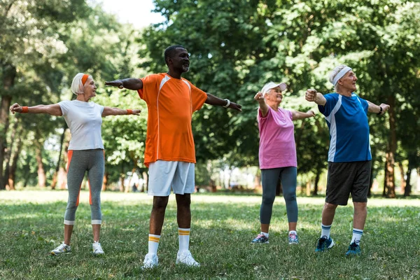 Felice milticulturale pensionati uomini e donne che lavorano su erba nel parco — Foto stock