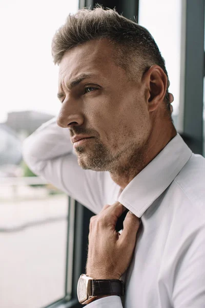 Nahaufnahme eines gutaussehenden Geschäftsmannes, der formelle Kleidung im Büro berührt — Stockfoto