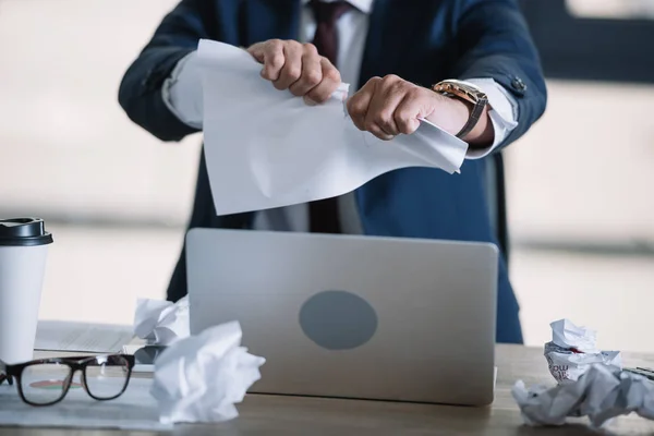 Обрізаний вид бізнесмена розриваючий папір в офісі — стокове фото