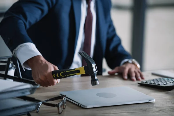 Обрізаний вид бізнесмена, що тримає молоток біля ноутбука в офісі — Stock Photo