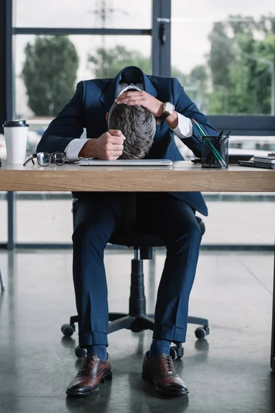 Homem de negócios sentado perto da mesa com copo de papel no escritório moderno — Fotografia de Stock