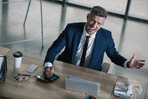 Blick über den Tellerrand: Emotionaler Geschäftsmann gestikuliert im Amt — Stockfoto