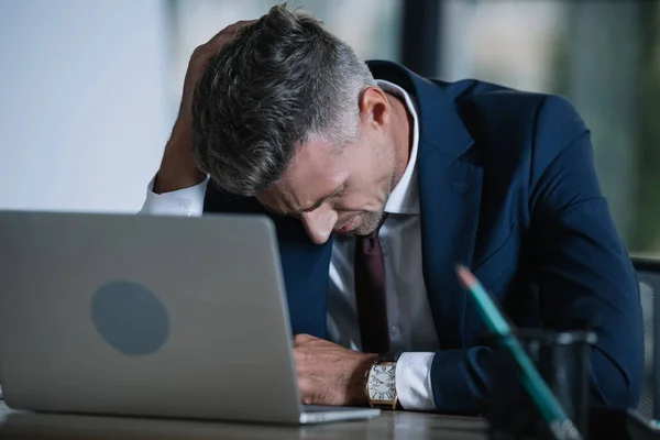 Foco seletivo de empresário chateado em desgaste formal perto de laptop no escritório — Fotografia de Stock
