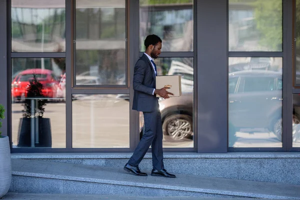 Afrikanisch-amerikanischer Geschäftsmann im Anzug mit Karton abgewiesen — Stockfoto