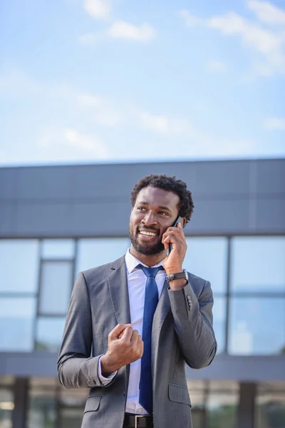 Homme d'affaires africain heureux montrant oui geste et sourire tout en parlant sur smartphone — Photo de stock
