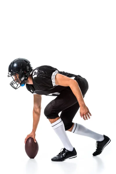 Vista lateral del jugador de fútbol americano con pelota aislada en blanco - foto de stock
