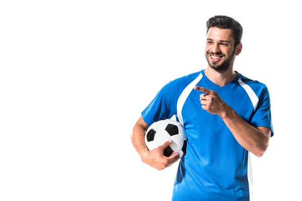 Jugador de fútbol feliz con la bola apuntando con el dedo aislado en blanco - foto de stock