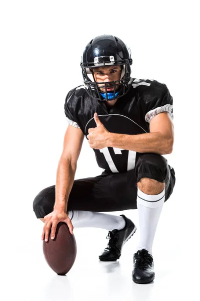 Jugador de fútbol americano con pelota haciendo el pulgar hacia arriba signo On White - foto de stock