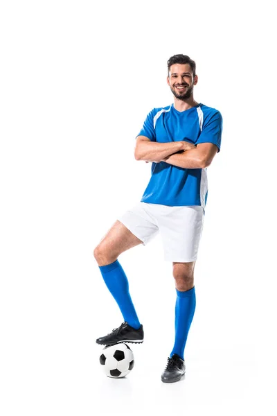 Feliz jugador de fútbol con pelota y brazos cruzados aislado en blanco - foto de stock