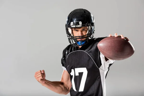 American Football player in helmet with ball Isolated On grey — Stock Photo