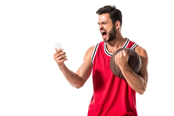 Joueur de basket hurlant avec balle en utilisant smartphone isolé sur blanc — Photo de stock