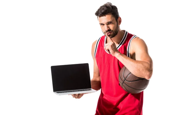 Jugador de baloncesto atlético con pelota y portátil haciendo gesto de silencio aislado en blanco - foto de stock