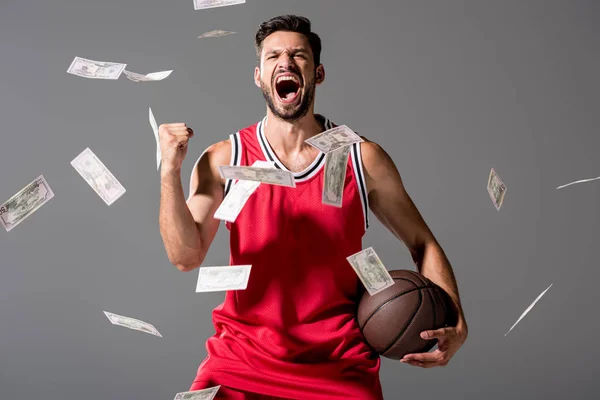 Gritando jogador de basquete com bola Isolado em cinza com dinheiro caindo — Fotografia de Stock