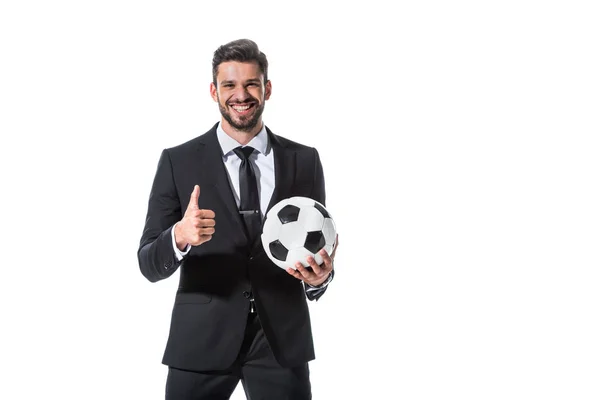Улыбающийся бизнесмен в формальной одежде с футбольным мячом, показывающим большой палец на белом — стоковое фото